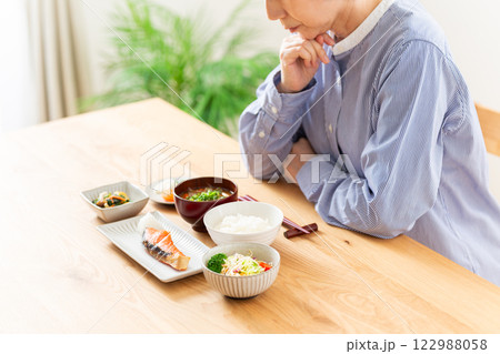 和食の朝食を前に悩むミドル女性 122988058