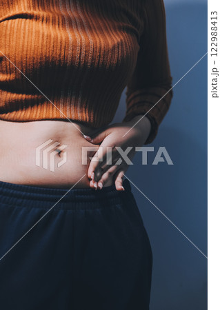 Asian Woman Pinching Her Belly Fat With Left Hand 122988413