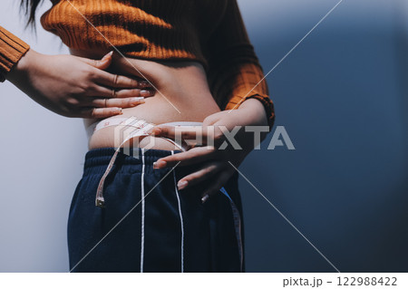 Asian Woman Pinching Her Belly Fat With Left Hand 122988422