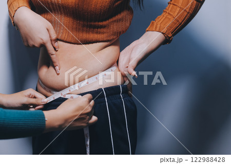 Asian Woman Pinching Her Belly Fat With Left Hand Asian Woman Pinching Her Belly Fat With Left Hand 122988428