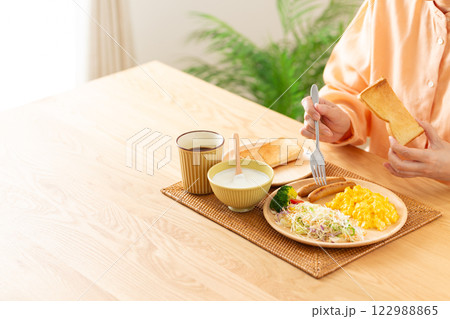 洋食の朝食でトーストを食べるミドル女性の手元 洋食の朝食でトーストを食べるミドル女性の手元 122988865