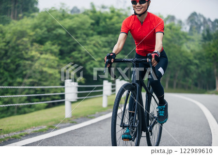 Asian woman cycling on summer trail 122989610