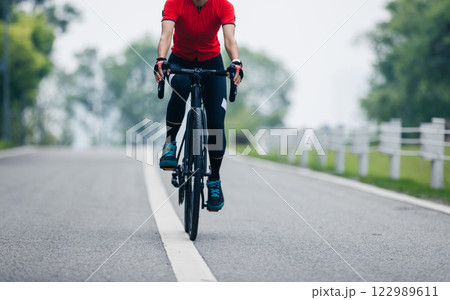 Asian woman cycling on summer trail 122989611