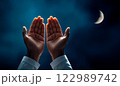 hand of a Muslim rising at night 122989742