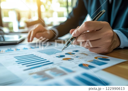 Business Professional Analyzing Financial Reports and Data with Charts and Graphs in Office 122990613