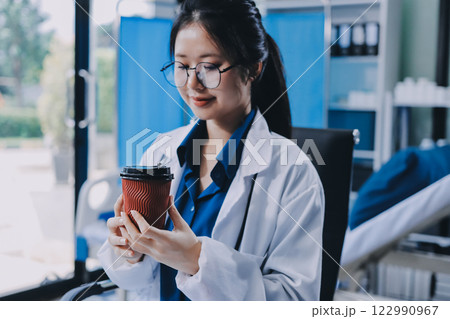 Medicine doctor hand working with modern digital tablet computer and holding coffee cup on white desk 122990967