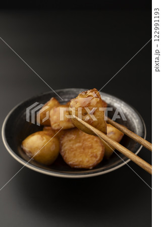 新じゃがの煮っころがしを箸で持ち上げる 新じゃがの煮っころがしを箸で持ち上げる 122991193