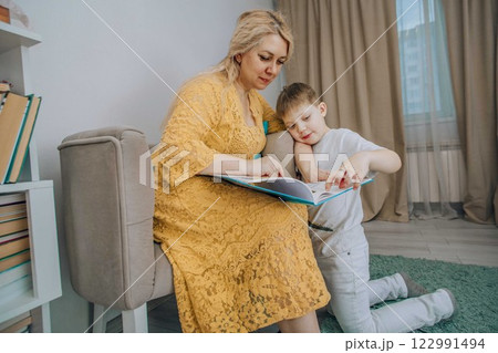 smiling child and adult sharing a book together in a peaceful home setting concept of storytelling, communication, and emotional intelligence smiling child and adult sharing a book together in a peaceful home setting concept of storytelling, communication, and emotional intelligence 122991494