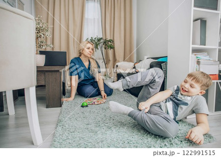 Therapist guiding a child in an interactive educational activity on the floor, demonstrating a playful approach to learning and child development, concept of hands-on pedagogy 122991515
