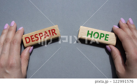 Despair or Hope symbol. Concept word Despair or Hope on wooden blocks. Businessman hand. Beautiful grey background. Business and Despair or Hope concept. Copy space 122991576