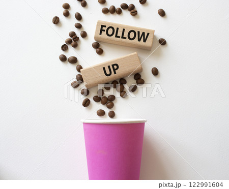Follow up symbol. Concept word Follow up on wooden blocks. Beautiful white background with coffee cup. Business and Follow up concept. Copy space 122991604