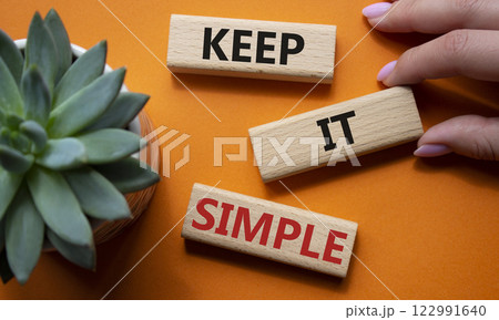 Keep it Simple symbol. Concept words Keep it Simple on wooden blocks. Businessman hand. Beautiful orange background with succulent plant. Business and Keep it Simple concept. Copy space. Keep it Simple symbol. Concept words Keep it Simple on wooden blocks. Businessman hand. Beautiful orange background with succulent plant. Business and Keep it Simple concept. Copy space. 122991640