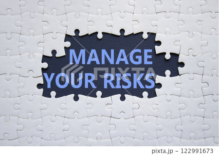 Risks symbol. Concept words Manage your Risks on white puzzle. Beautiful deep blue background Business and Manage your Risks concept. Copy space. 122991673