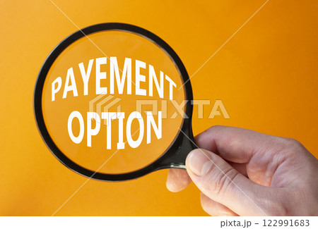 Payment Options symbol. Concept words Payment Options on magnifying glass. Businessman hand. Beautiful orange background. Business and Payment Options concept. Copy space. Payment Options symbol. Concept words Payment Options on magnifying glass. Businessman hand. Beautiful orange background. Business and Payment Options concept. Copy space. 122991683