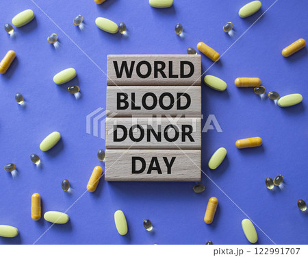 World Blood Donor Day symbol. Concept word World Blood Donor Day on wooden blocks. Beautiful purple background with pills. Medicine and World Blood Donor Day concept. Copy space 122991707
