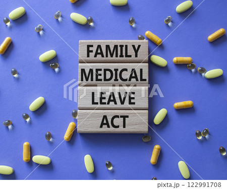 Family Medical Leave Act symbol. Concept word Family Medical Leave Act on wooden blocks. Beautiful purple background with pills. Medicine concept. Copy space 122991708