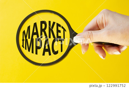 Market impact symbol. Concept word Market impact on magnifying glass. Beautiful yellow background. Businessman hand. Business and Market impact concept. Copy space. 122991752