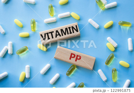 Vitamin PP symbol. Concept word Vitamin PP on wooden blocks. Beautiful pink background with pills. Medicine and Vitamin PP concept. Copy space Vitamin PP symbol. Concept word Vitamin PP on wooden blocks. Beautiful pink background with pills. Medicine and Vitamin PP concept. Copy space 122991875