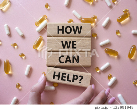 How we can help symbol. Concept word How we can help on wooden blocks. Businessman hand. Beautiful pink background with pills. Medicine and How we can help concept. Copy space How we can help symbol. Concept word How we can help on wooden blocks. Businessman hand. Beautiful pink background with pills. Medicine and How we can help concept. Copy space 122991949