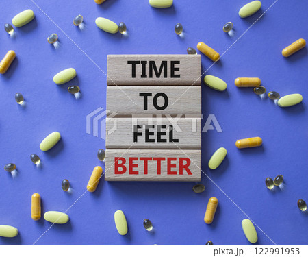 Time to feel better symbol. Concept word Time to feel better on wooden blocks. Beautiful purple background with pills. Health concept. Copy space Time to feel better symbol. Concept word Time to feel better on wooden blocks. Beautiful purple background with pills. Health concept. Copy space 122991953