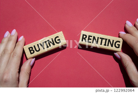 Buying or Renting symbol. Concept word Buying or Renting on wooden blocks. Businessman hand. Beautiful red background. Business and Buying or Renting concept. Copy space 122992064