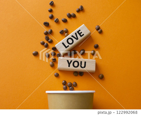 Love you symbol. Concept word Love you on wooden blocks. Beautiful orange background with coffee cup. Business and Love you concept. Copy space Love you symbol. Concept word Love you on wooden blocks. Beautiful orange background with coffee cup. Business and Love you concept. Copy space 122992068