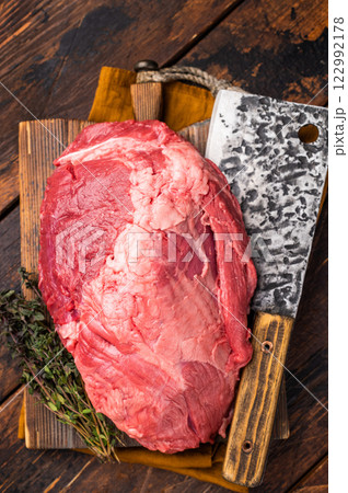 Fresh raw boneless beef shank displayed on a wooden cutting board, showcasing its rich color and marbling, perfect for hearty soups and stews. wooden background. top view Fresh raw boneless beef shank displayed on a wooden cutting board, showcasing its rich color and marbling, perfect for hearty soups and stews. wooden background. top view 122992178