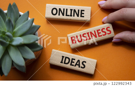 Online Business Ideas symbol. Wooden blocks with words Online Business Ideas. Beautiful orange background with succulent plant. Businessman hand. Business concept. Copy space. 122992343
