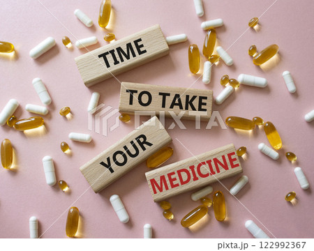 Time to take your Medicine symbol. Concept word Time to take your Medicine on wooden blocks. Beautiful pink background with pills. Health concept. Copy space Time to take your Medicine symbol. Concept word Time to take your Medicine on wooden blocks. Beautiful pink background with pills. Health concept. Copy space 122992367