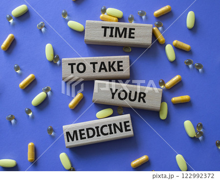 Time to take your Medicine symbol. Concept word Time to take your Medicine on wooden blocks. Beautiful purple background with pills. Health concept. Copy space 122992372