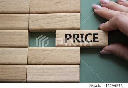 Price symbol. Concept word Price on wooden blocks. Beautiful grey green background. Businessman hand. Business and Price concept. Copy space. 122992384
