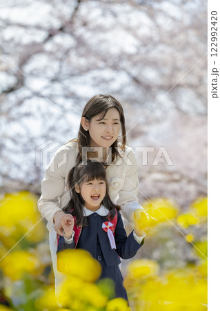 桜と菜の花の咲く公園を楽しむ入学の娘と母親 桜と菜の花の咲く公園を楽しむ入学の娘と母親 122992420