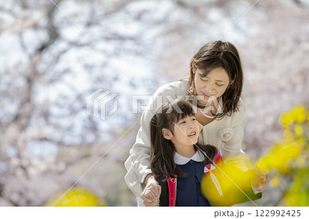 桜と菜の花の咲く公園を楽しむ入学の娘と母親 122992425