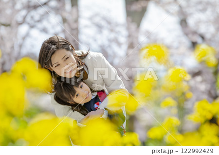 桜と菜の花の咲く公園を楽しむ入学の娘と母親 桜と菜の花の咲く公園を楽しむ入学の娘と母親 122992429
