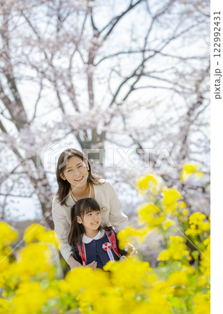 桜と菜の花の咲く公園を楽しむ入学の娘と母親 桜と菜の花の咲く公園を楽しむ入学の娘と母親 122992431