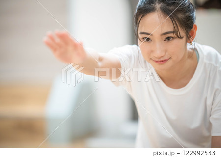室内のジムで筋肉トレーニングをする若い女性 室内のジムで筋肉トレーニングをする若い女性 122992533