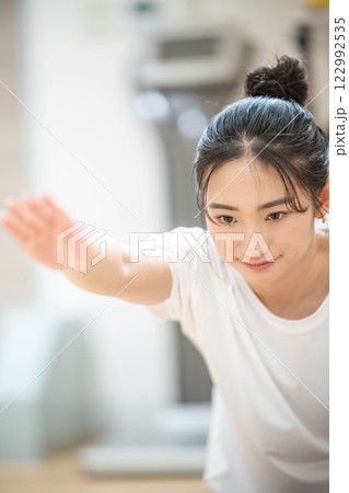 室内のジムで筋肉トレーニングをする若い女性 室内のジムで筋肉トレーニングをする若い女性 122992535
