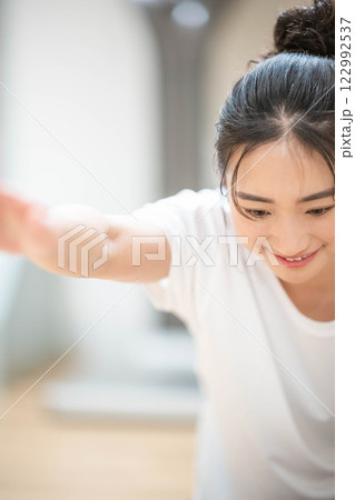 室内のジムで筋肉トレーニングをする若い女性 室内のジムで筋肉トレーニングをする若い女性 122992537