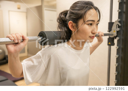 室内のジムで筋肉トレーニングをする若い女性 122992591