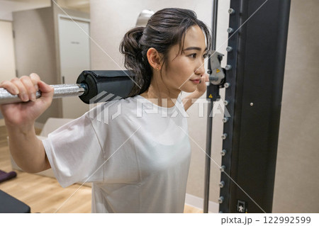 室内のジムで筋肉トレーニングをする若い女性 122992599