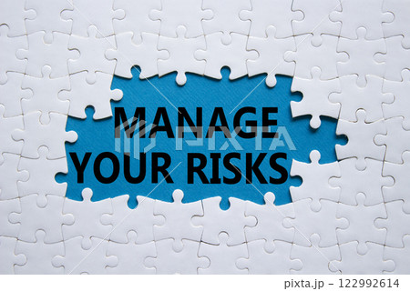 Risks symbol. Concept words Manage your Risks on white puzzle. Beautiful blue background Business and Manage your Risks concept. Copy space. 122992614
