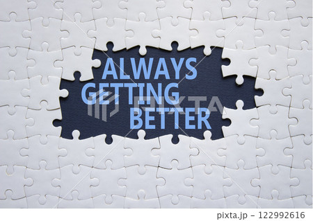 Always getting better symbol. White puzzle with words Always getting better. Beautiful deep blue background. Business and Always getting better concept. Copy space. 122992616