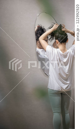 トレーニングジムで髪をセットする若い女性 トレーニングジムで髪をセットする若い女性 122992920