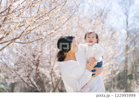 桜の咲く公園で遊ぶ母と娘 122993999