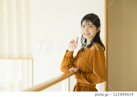 吹き抜けのある注文住宅と女性　 122994014