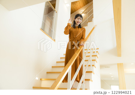 吹き抜けのある注文住宅と女性　 122994021