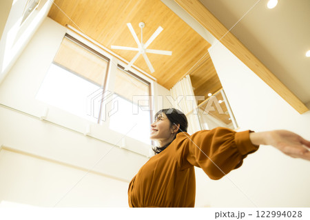 吹き抜けのある注文住宅と女性　 122994028