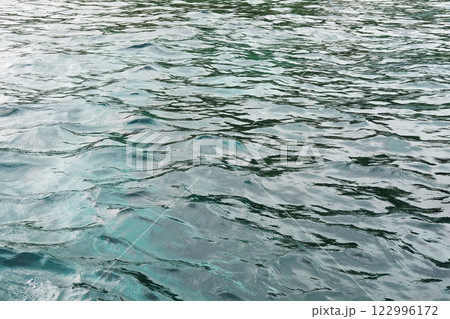 Emerald green waters and turquoise surface of blue sea wave and water background of shore. Travel destination summer of ocean 122996172