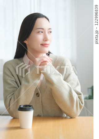 テーブルに座ってオフィスの窓から外を見るビジネスウーマン 　　　　　 122996839