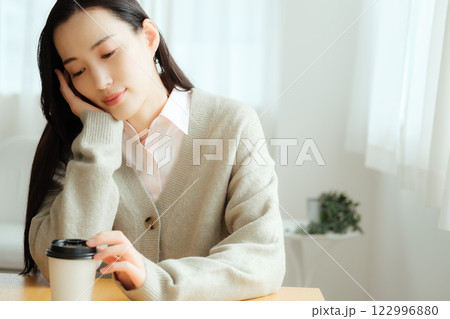 テーブルに座って考え事をするビジネスウーマン 　　　　　 122996880